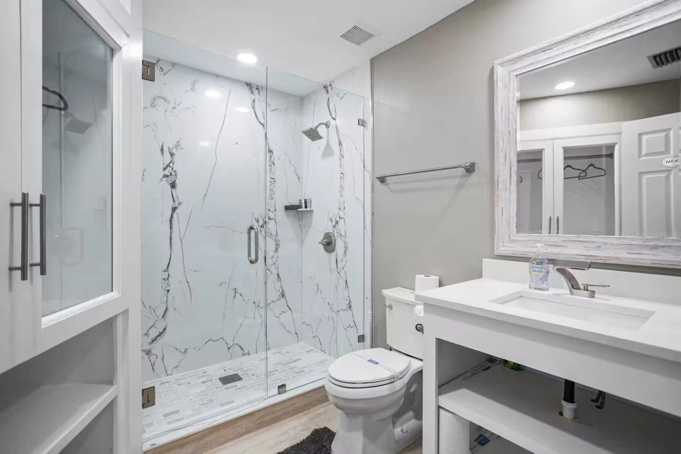 Bathroom with a full height marble effect shower surround and a white quartz vanity top